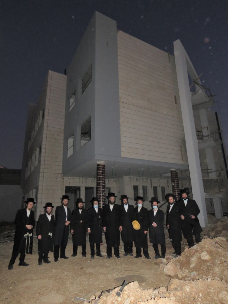 צוות המלמדים על רקע בנייני שטפנשט אלעד שהגיעו לשלבי הסיום של הבניה